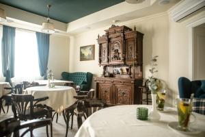ヴィーンヌィツャにあるChurchill-Innのテーブル2台と大きな木造キャビネット付きのレストラン