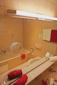 a bathroom with a tub and a sink and a mirror at Pension Walserheim in Lech am Arlberg