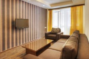 a living room with a couch and a tv at Tsaghkahovit Hotel in Tsaghkadzor