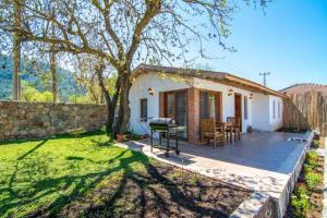 a small house with a wooden deck in the yard at Hackberry in Kayakoy