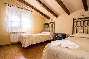 オヨス・デル・エスピーノにあるEl Leñador IIのウッドフロアのベッドルーム1室(ベッド2台、窓付)が備わります。