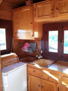 a kitchen with wooden cabinets and a sink at Cabana de Santo António in Vila Nova de Cerveira