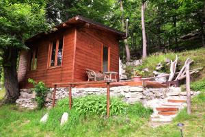 a small wooden cabin with a chair in a field at Ca-Jo Bed and Breakfast in Garessio