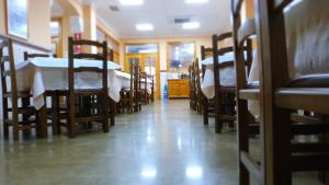 pokój z kilkoma stołami i krzesłami oraz pokój w obiekcie Hostal Restaurante La Masía w mieście Villareal