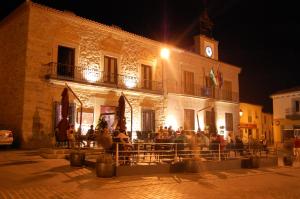 een groep mensen die 's nachts buiten een gebouw zitten bij Hotel Los Usías in Dos Torres