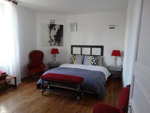1 dormitorio con 1 cama y 1 silla roja en Chambres d'Hôtes A Buglose, en Saint-Vincent-de-Paul