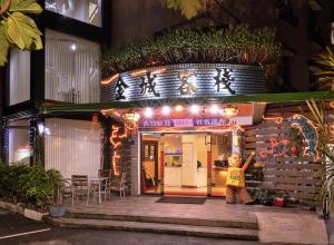 een persoon die 's nachts buiten een restaurant staat bij King Town Hotel in Luodong