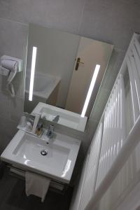 a bathroom with a sink and a mirror at Hotel De La Digue in Le Mont Saint Michel