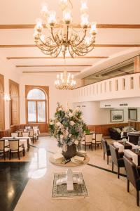 a large dining room with a large vase of flowers at Grand Hotel Sole in Nitra