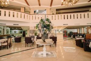 eine Lobby mit einem Tisch mit Blumen darauf in der Unterkunft Grand Hotel Sole in Nitra