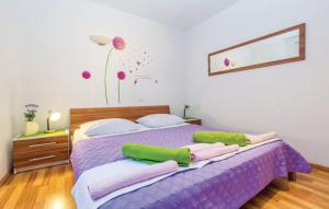 een slaapkamer met een paars bed met groene kussens bij Apartment Ivan Mili in Senj