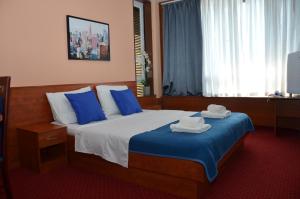 um quarto de hotel com uma cama grande com almofadas azuis em Liberty Hotel em Novalja