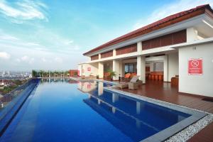 a swimming pool in front of a building at Wimarion Hotel Semarang in Semarang