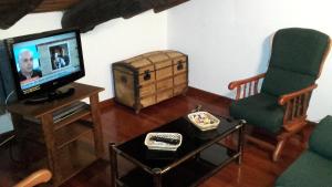 a living room with a tv and a chair at La Posá in Acehuche