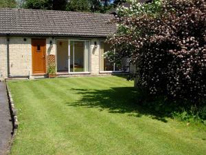 a house with a yard with a large lawn at Bobby's Nook in Stroud