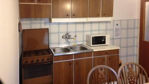 a small kitchen with a sink and a microwave at Villa Bencun in Medulin