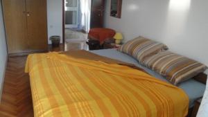 ein Bett mit einer orangen und gelben Decke drauf in der Unterkunft Villa Bencun in Medulin