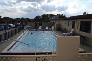 una grande piscina con sedie in un parcheggio di Atlantic Economy Inn a Daytona Beach Altre 16 foto