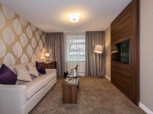 a living room with a couch and a tv at The Melbreak Hotel in Great Clifton