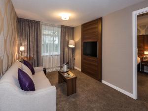 a living room filled with furniture and a tv at The Melbreak Hotel in Great Clifton