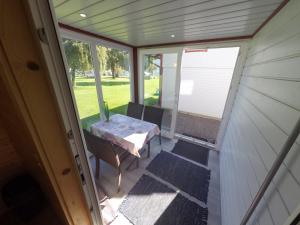 eine abgeschirmte Veranda mit einem Tisch und einem Fenster in der Unterkunft Ferienhaus Blasge in Bodensdorf