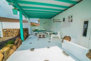 eine Terrasse mit blauer Decke sowie einem Tisch und Stühlen in der Unterkunft Casa El Cerco in Tabayesco