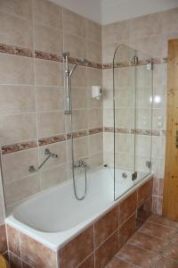 a bathroom with a tub and a glass shower at Autobahnrestaurant & Motorhotel Zöbern in Zöbern +13 photos