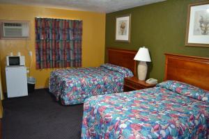 una camera d'albergo con due letti e una lampada di Atlantic Economy Inn a Daytona Beach