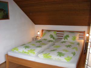 - une chambre dotée d'un lit avec des feuilles vertes dans l'établissement Haus Osterrieder, à Sankt Michael im Lungau