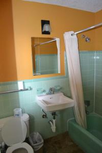 uma casa de banho com um lavatório, um WC e um espelho. em Atlantic Economy Inn em Daytona Beach