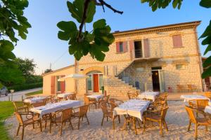 a group of tables and chairs in front of a building at Agriturismo Casa Rossi di Paolo Rossi in Numana