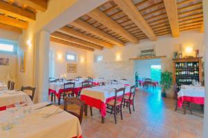 a restaurant with tables and chairs with red and white tablecloths at Agriturismo Casa Rossi di Paolo Rossi in Numana