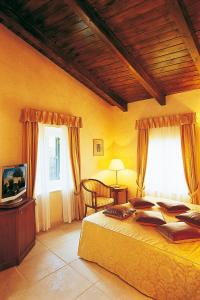 a bedroom with a large bed and a television at Siora Vittoria Boutique Hotel in Corfu