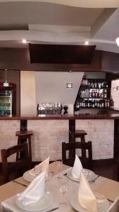 una sala da pranzo con due tavoli e un bar di Pensiunea Argesu ** a Sinaia