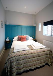 um quarto com uma cama grande e uma cabeceira azul em The Coach House em Potton