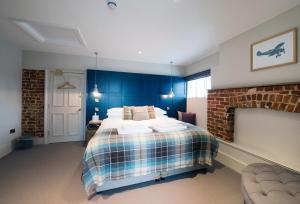 a bedroom with a large bed with blue walls at The Coach House in Potton