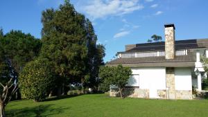 una casa vieja con un árbol y un patio de césped en Casa Rural Caserío el Molín, en La Caridad