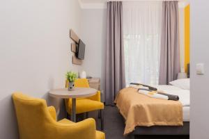 a hotel room with two beds and a table and chairs at Solaris in Pobierowo