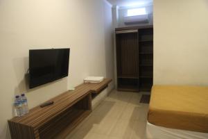 Habitación pequeña con TV en la pared en Palapa Hotel, en Mataram