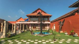 a large house with a fountain in the yard at Ginger House Museum Hotel in Cochin