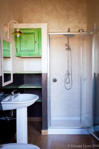 a bathroom with a sink and a shower with a glass door at Agriturismo Le Vigne Ducali in Màndas