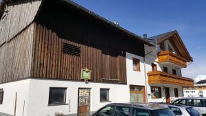 un edificio con una fachada de madera con coches aparcados fuera en Stanahof, en Galtür