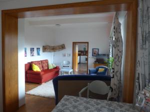 ein Wohnzimmer mit einem roten Sofa und einem Tisch in der Unterkunft O11- Großzügige Fewo im Künstlerhaus in Lichtenfels-Sachsenberg