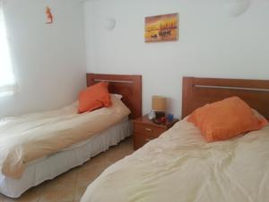 two beds in a room with two orange pillows at Praia da Luz Apartments in Luz