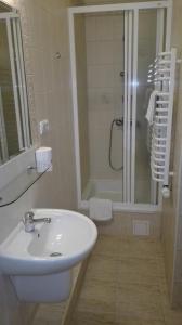 a white bathroom with a sink and a shower at Boży Dar in Krynica Zdrój