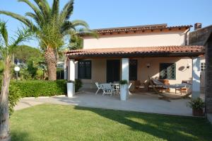 a house with a patio with a table and chairs at Villa Paola in Fontane Bianche