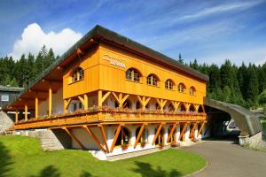 a building with a bridge with people on it at Hotel Lesana in Špindlerův Mlýn