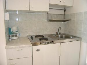 a small kitchen with a sink and a stove at Apartments Murgic in Krk