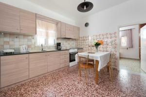 a kitchen with a table with a vase of flowers on it at Filerimos House in Ialysos