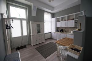 a kitchen with white cabinets and a wooden table at Apartament Maria in Timişoara